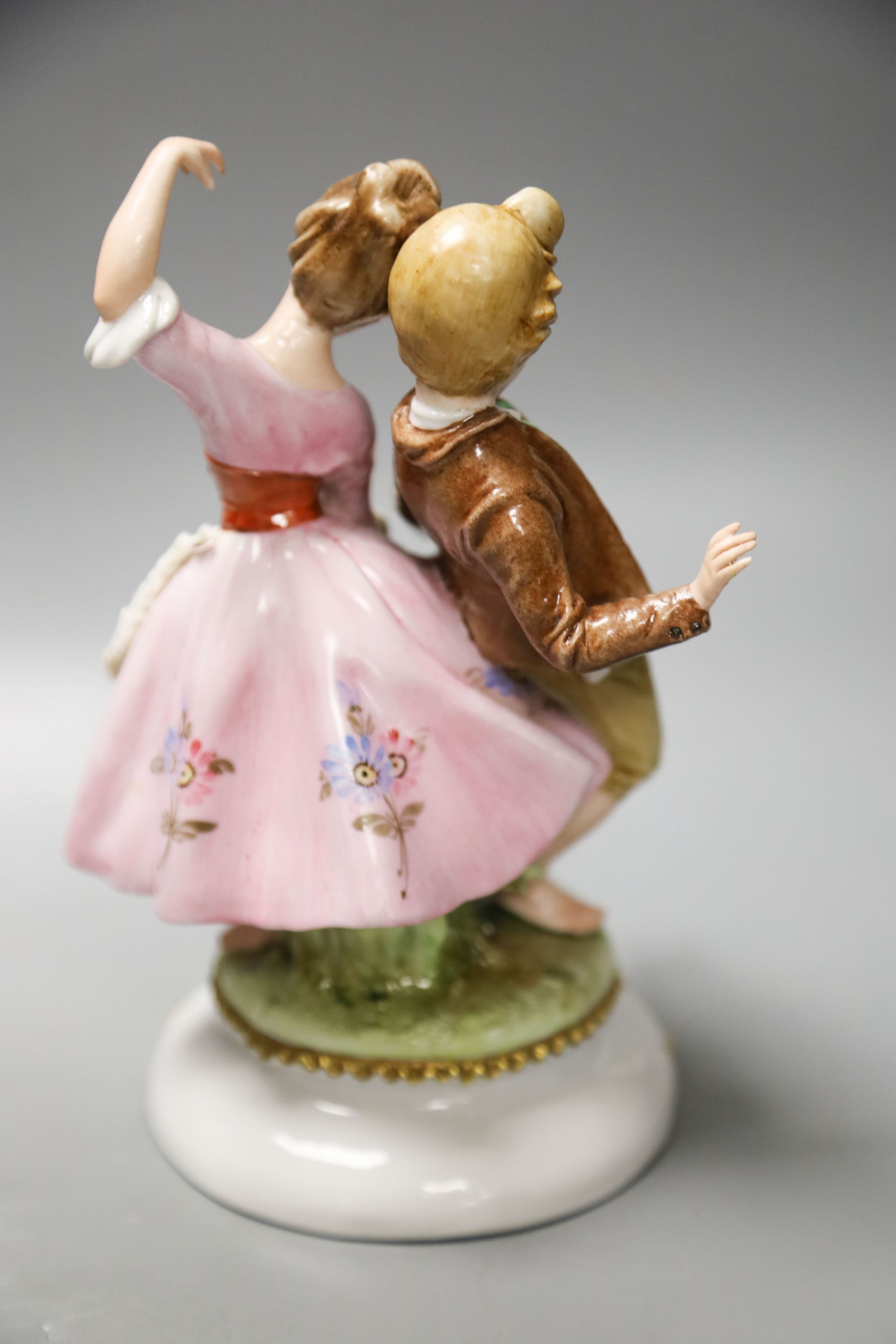 A Luigi Fabris porcelain figure of a lady wearing a crinoline dress, holding baskets of flowers, and two other figural groups (3)